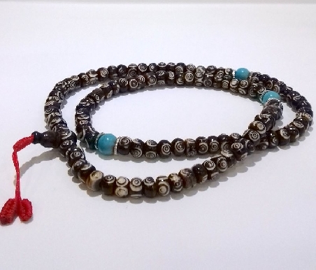 Mala de hueso oscuro grabado con pedrería